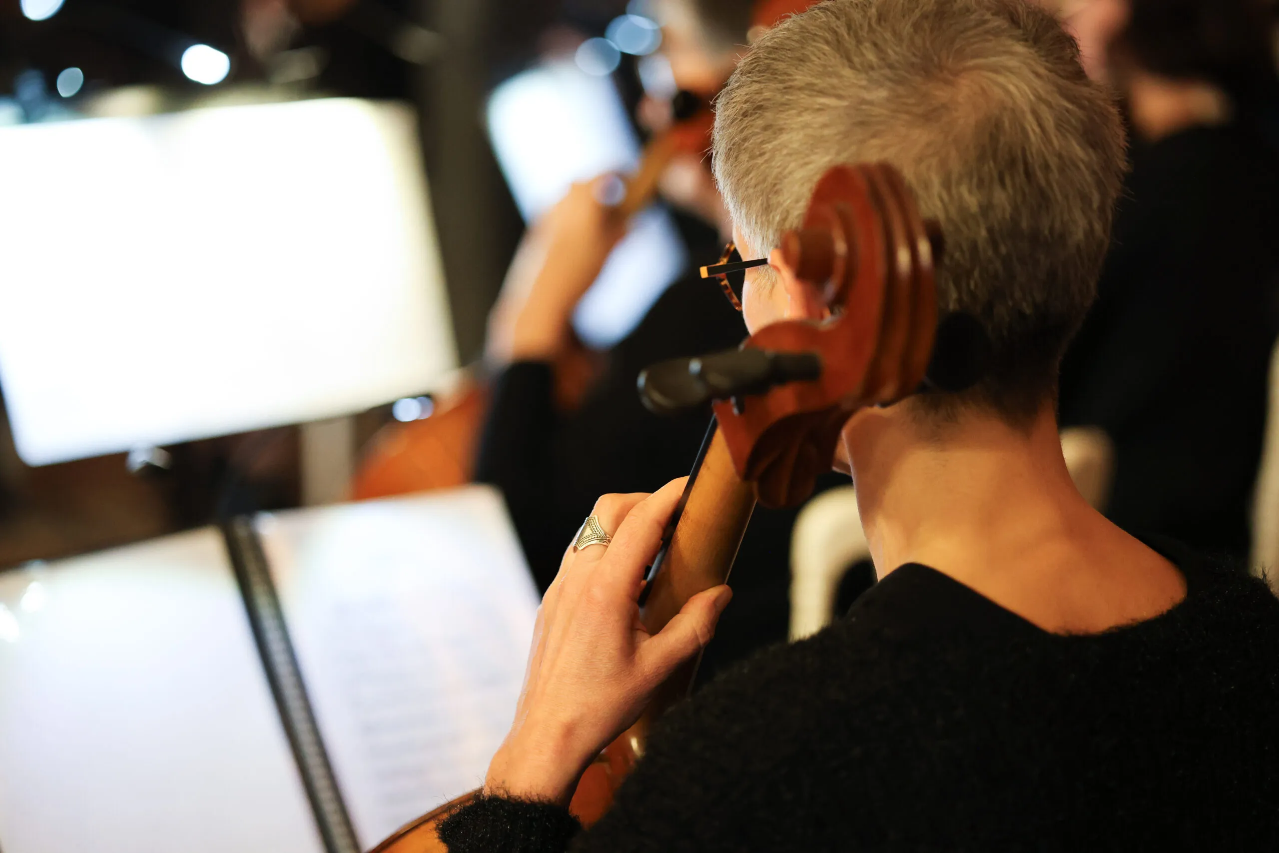 Violoncelliste en répétition, partition ouverte